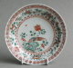 A Chinese saucer, moulded with petals, and decorated with famille verte enamels, Kangxi