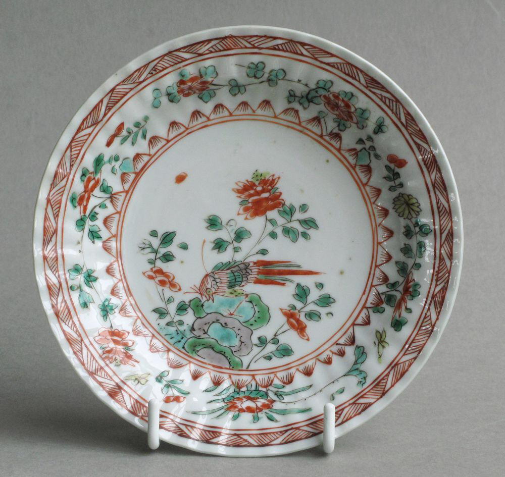A Chinese saucer, moulded with petals, and decorated with famille verte enamels, Kangxi