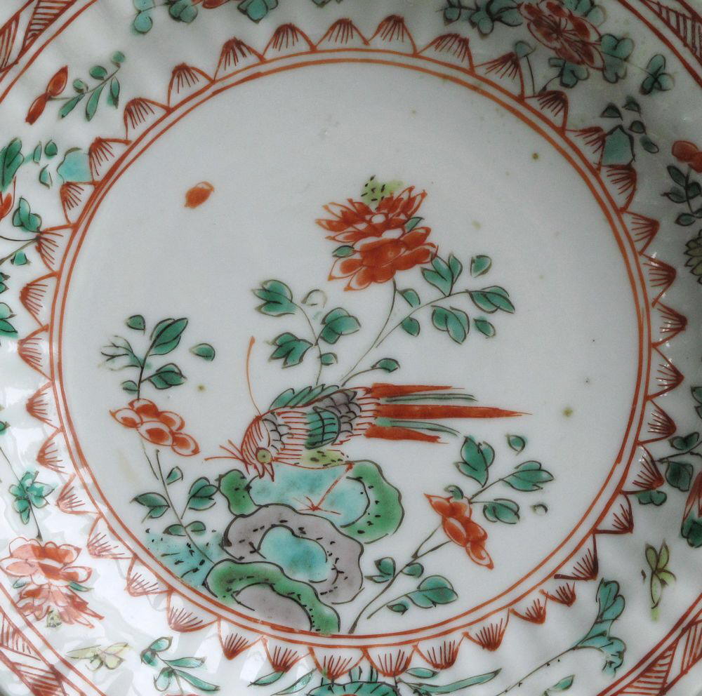 A Chinese saucer, moulded with petals, and decorated with famille verte enamels, Kangxi
