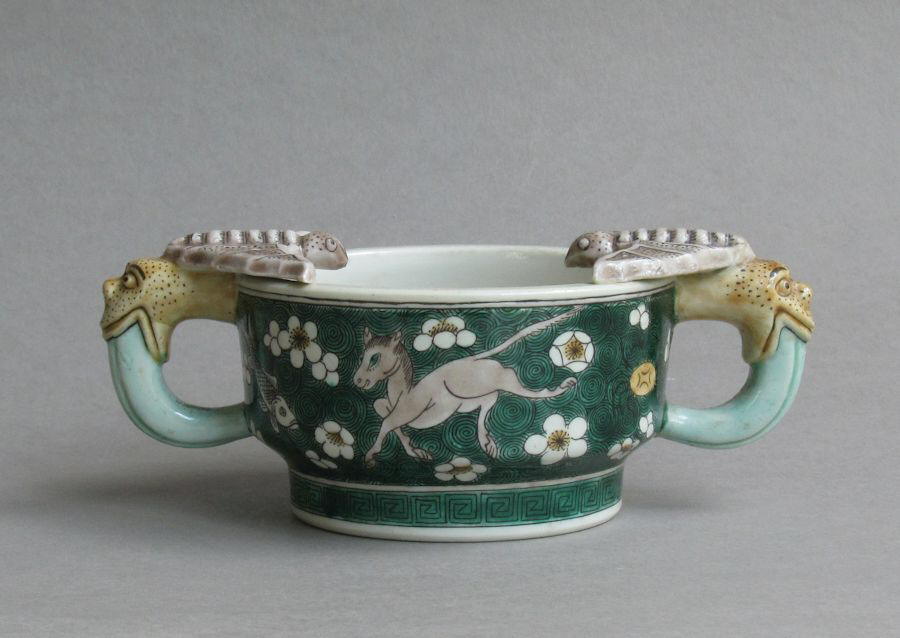 An attractive Chinese cup with leopard handles, decorated on the biscuit with susancai famille verte colours