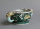 An attractive Chinese cup with leopard handles, decorated on the biscuit with susancai famille verte colours